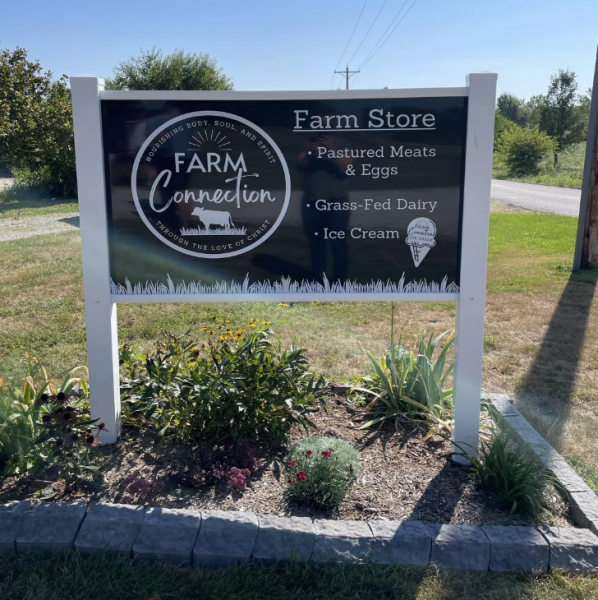 Sign with words Farm Connection, Farm Store, Pastured Meat & Eggs, Grass-Feb Dairy and Ice Cream on it.