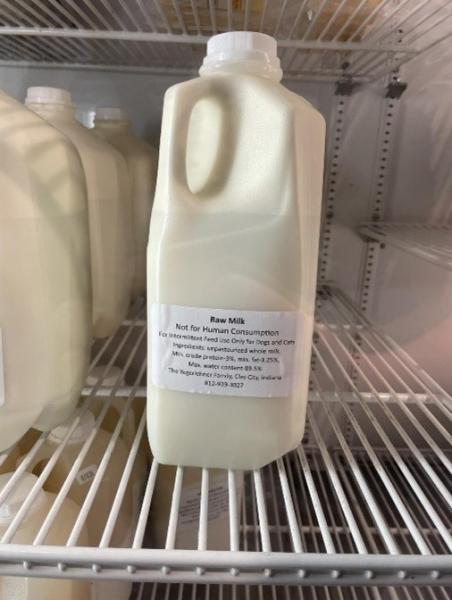 Bottles of milk in an open fridge