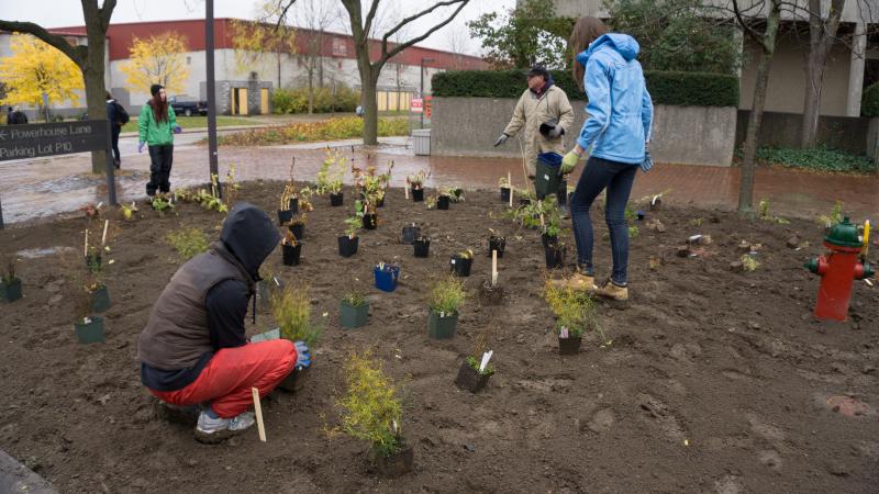 Rodger and students planting flowers in front of the Crop Science building