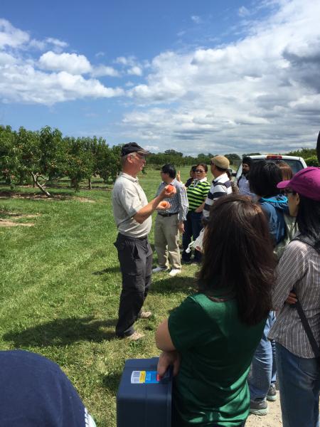 Glen Alm talks to the group about the peaches