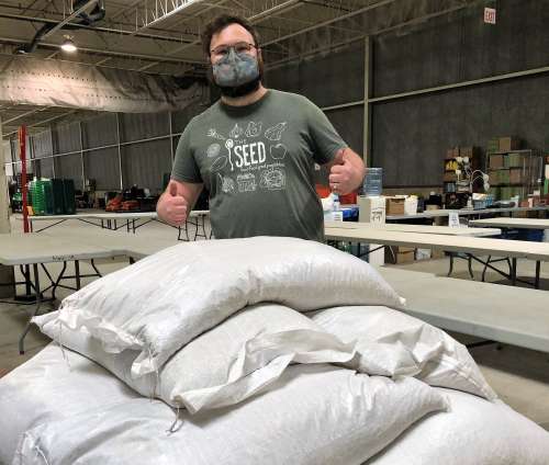 Riley Goltz with The SEED receiving 700kg of dry beans grown by U of G dry bean breeding program.