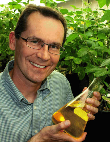 Istvan Rajcan holding flask containing soybean oil
