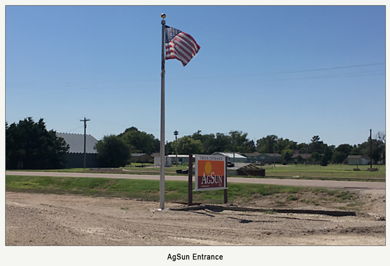 truck entrance sign to AgSun with American flag pole
